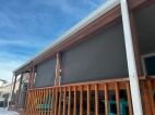 custom exterior roller shade mounted on residential patio